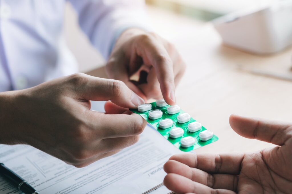 Doctor is pointing to drug tablet and introducing the properties of the painkiller to patient