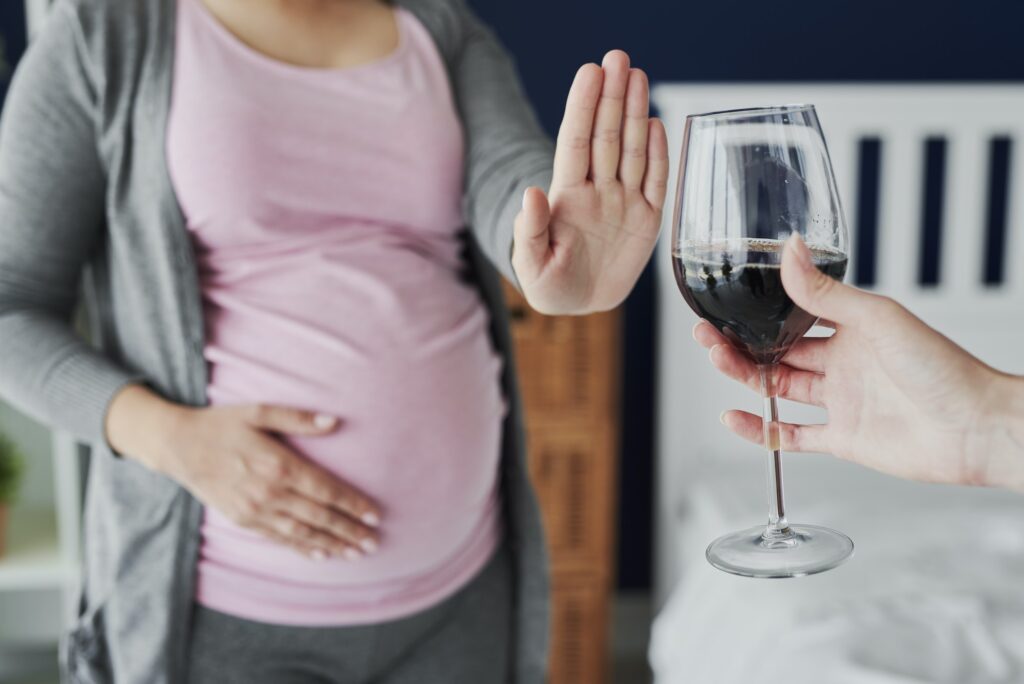 Pregnant woman refusing a glass of wine