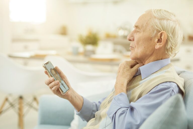 Pensioner looking at smartphone and chatting online with a doctor