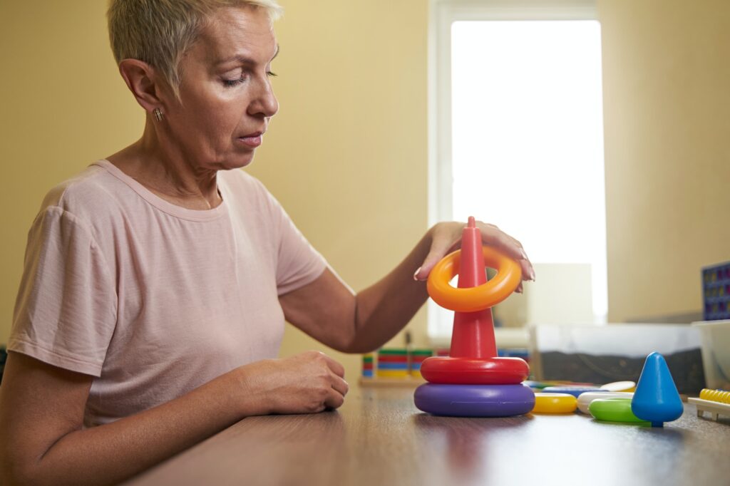 Photo of ergotherapy with stroke woman in rehab center