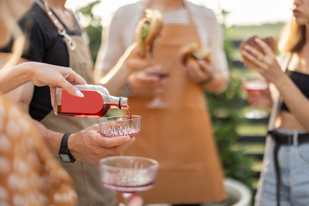 Friends pouring alcohol at picnic