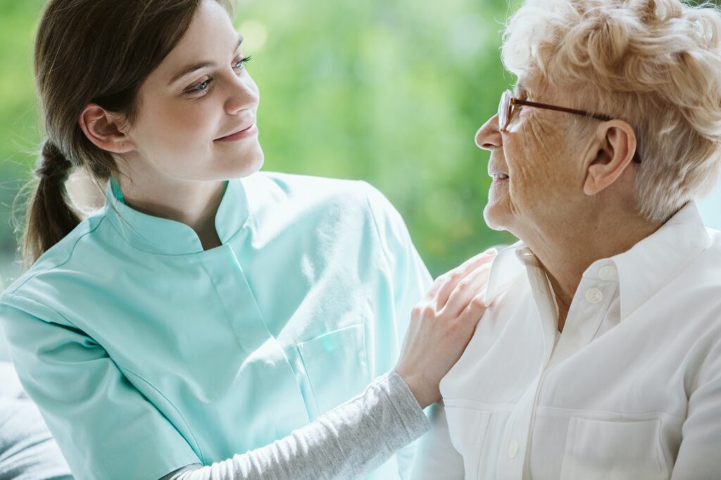 Happy senior woman and helpful caregiver, nursing home concept photos
