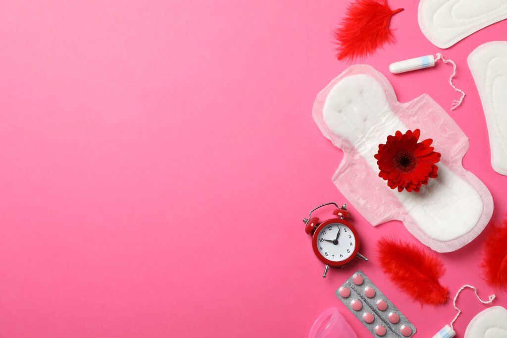 Menstrual period concept on pink background, top view