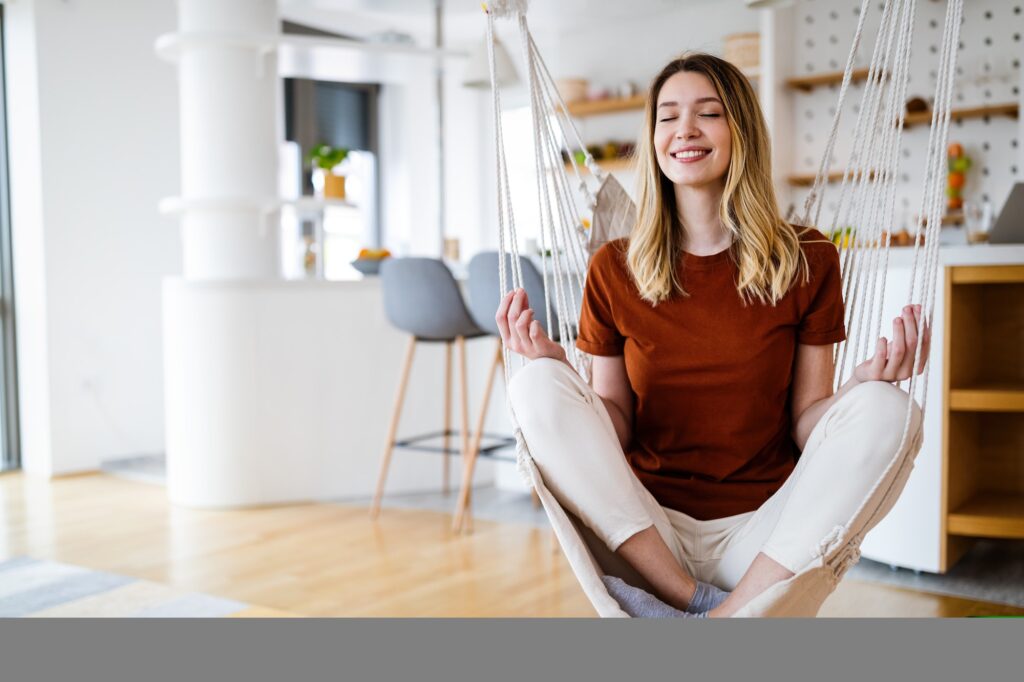Peaceful woman practicing yoga at home relaxing with eyes closed. Stress free concept