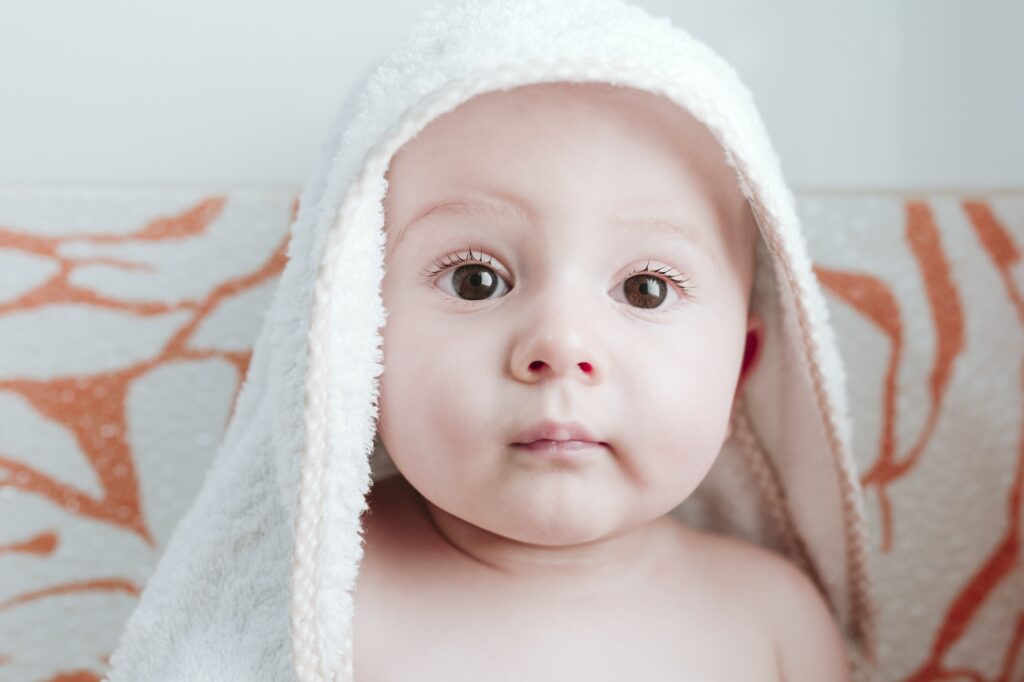 baby boy getting dried with towel in bathroom.