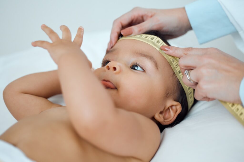 Shot of a paediatrician measuring a babys head in a clinic