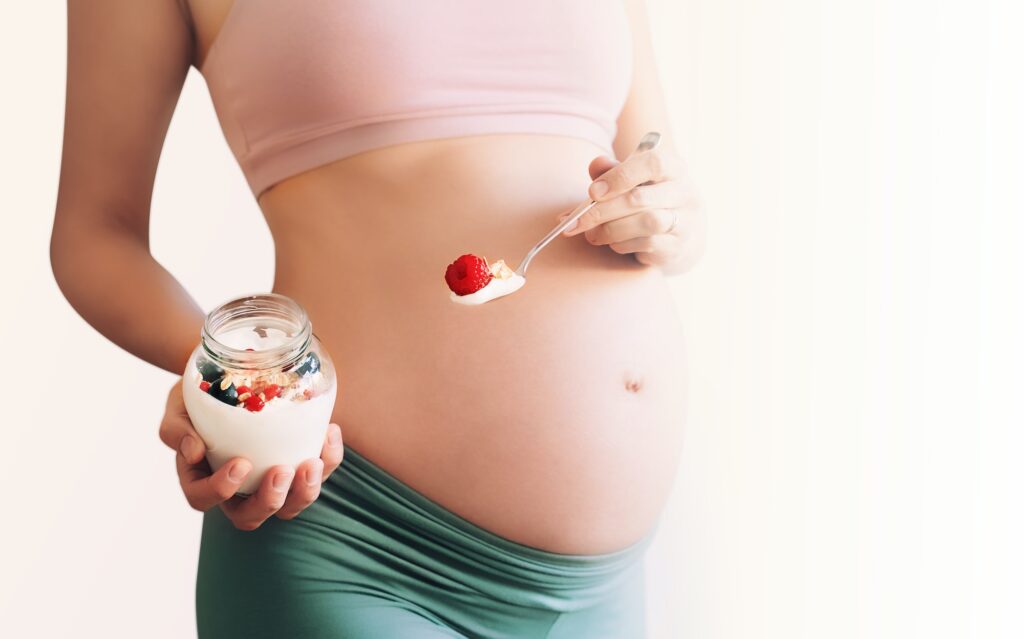 Nutrition and wellbeing during pregnancy. Pregnant woman with healthy food.