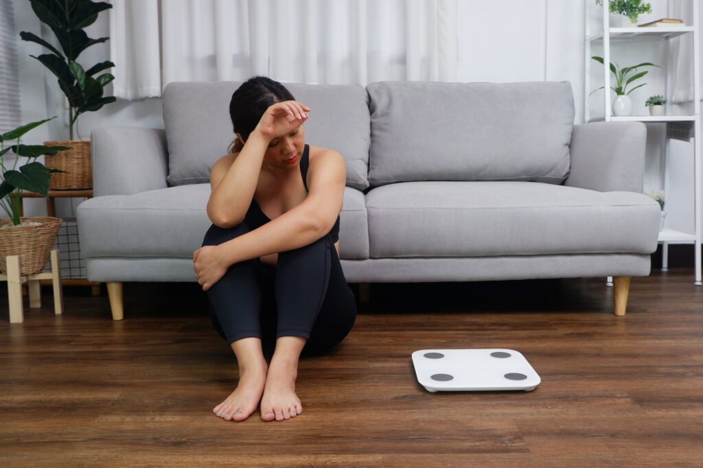 Women looking at weight scale try to loose weight