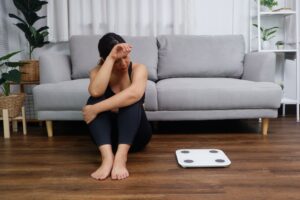 Women looking at weight scale try to loose weight