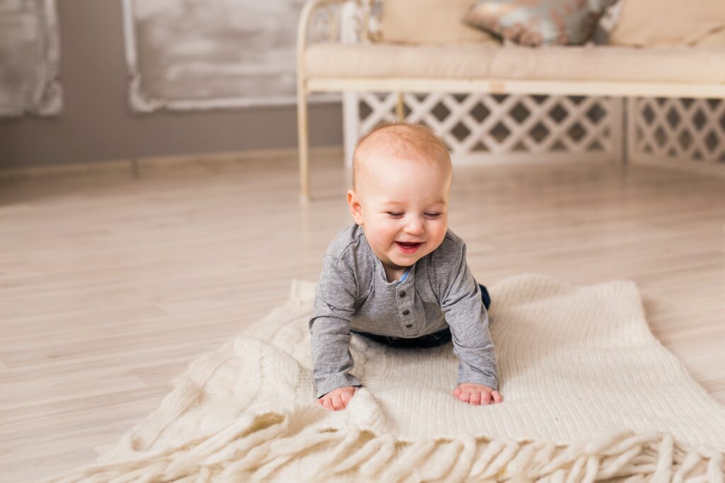 Laughing Baby Boy Lying On Tummy At Home