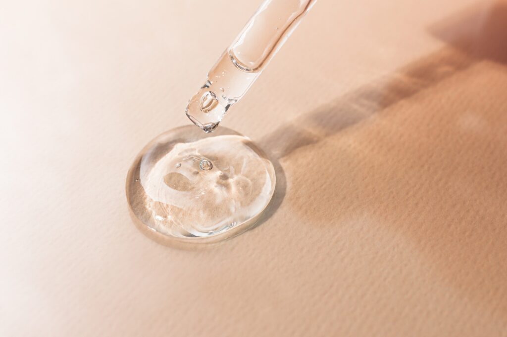 Transparent hyaluronic gel for skin care and hydration close-up on a colored background.
