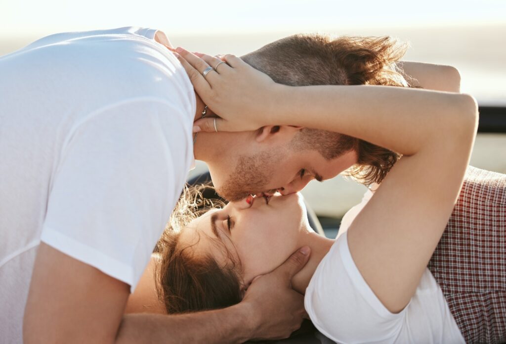 Couple, love and kiss with a man and woman on a road trip for their honeymoon, vacation or travel.