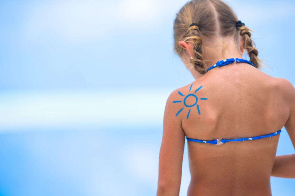 Sun painted by sun cream on kid shoulder