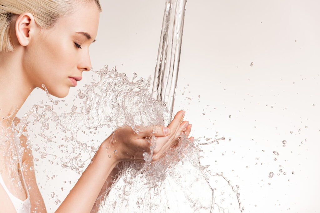 Photo of young woman with clean skin and splash of water.