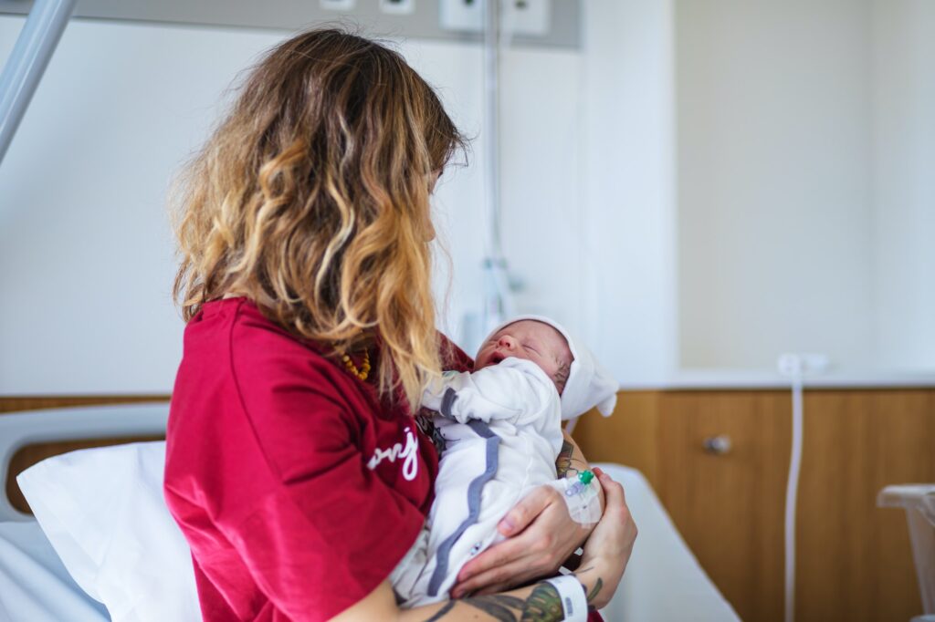 after giving birth a woman holds a baby in her arms