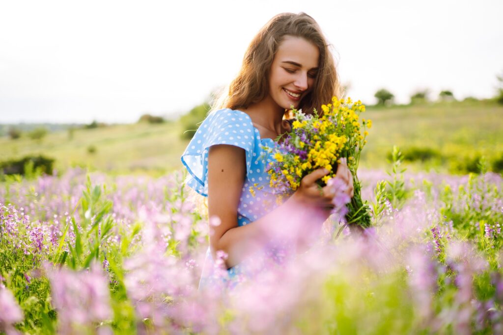 Beautiful woman in the blooming field. Nature, vacation, relax and lifestyle. Summer landscape.
