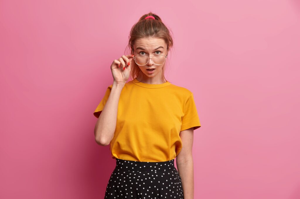 Half length shot of astonished female student cannot believe in her results on exams looks wondered