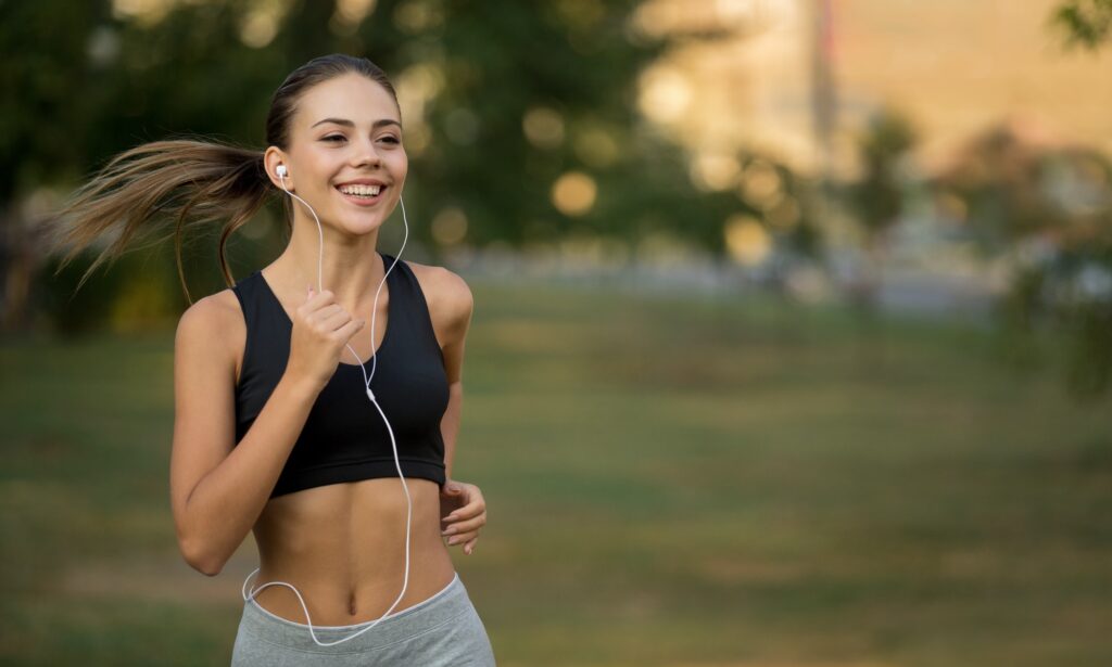 Happy active woman running and listening to music