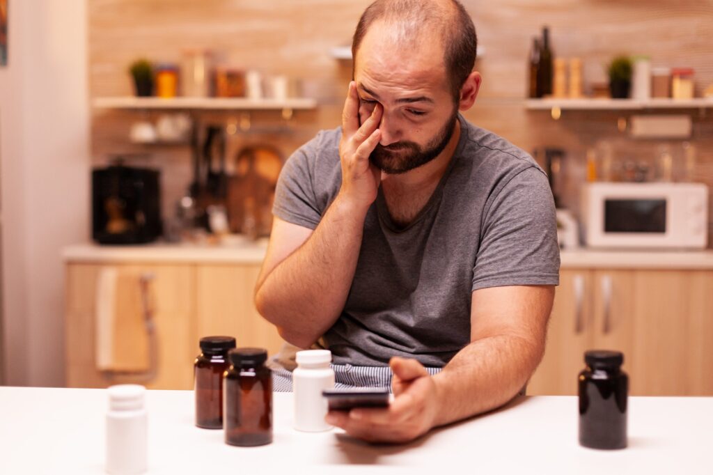 Man with pain searching on the phone medical treatment