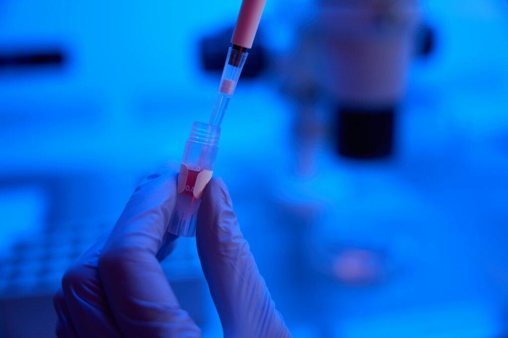 Person works with biomaterial from a test tube