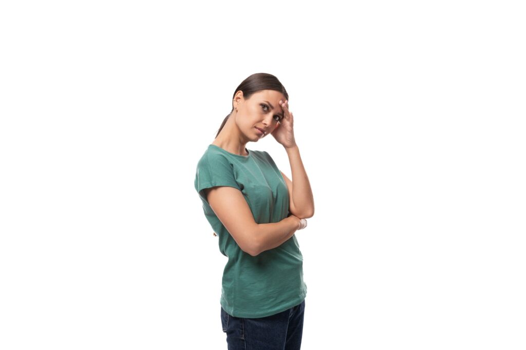 young brunette woman thinking while standing alone