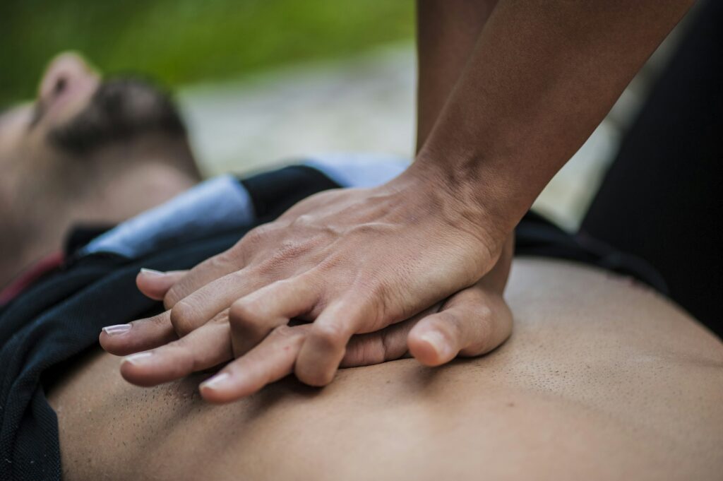 girl making cardiopulmonary resuscitation to an unconscious guy after heart attack