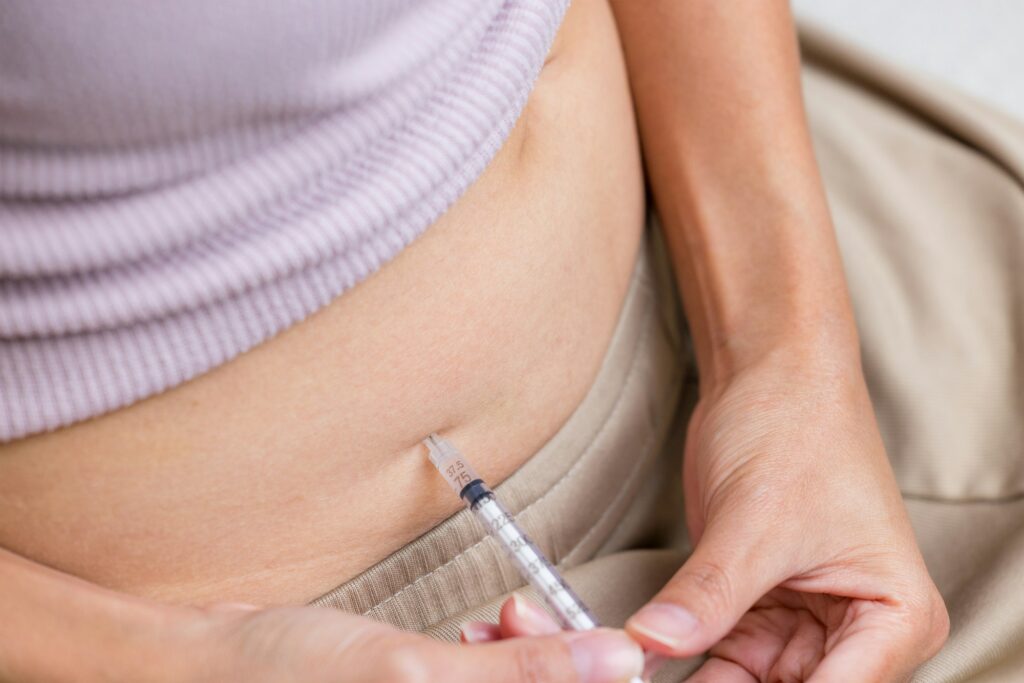 IVF and infertility treatment concept, woman have injection on her belly
