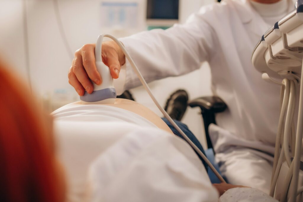 Ultrasound examination of the fetus. Pregnant woman in gynecological surgery. Gynecologist.