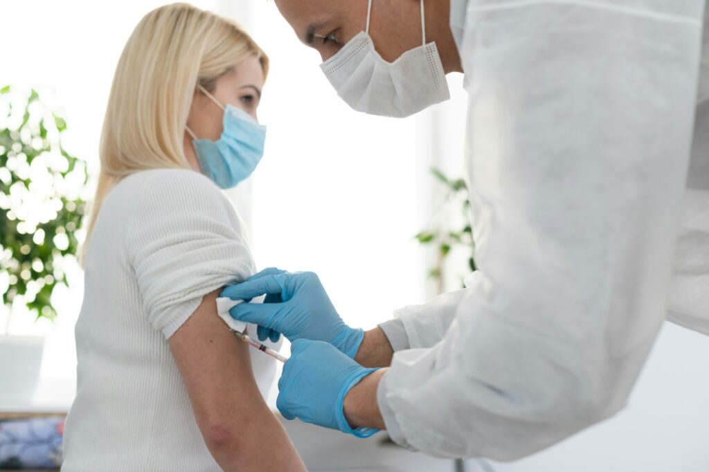 Doctor injecting vaccine to woman, covid vaccine