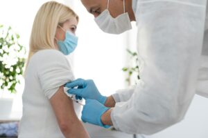 Doctor injecting vaccine to woman, covid vaccine