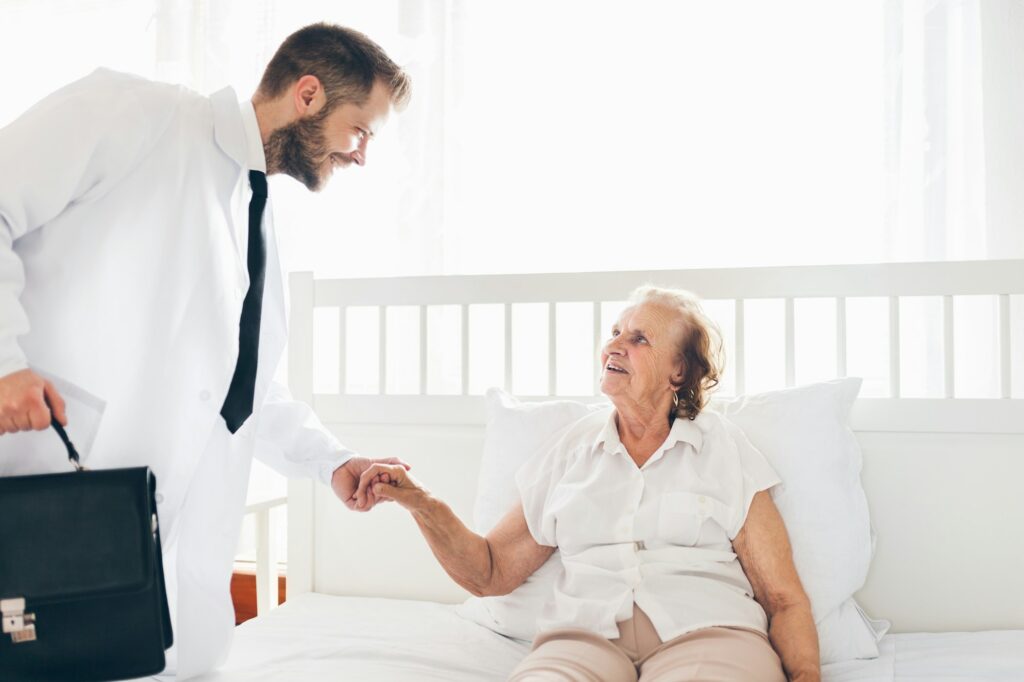 Providing care for elderly. Doctor visiting elderly patient at home.
