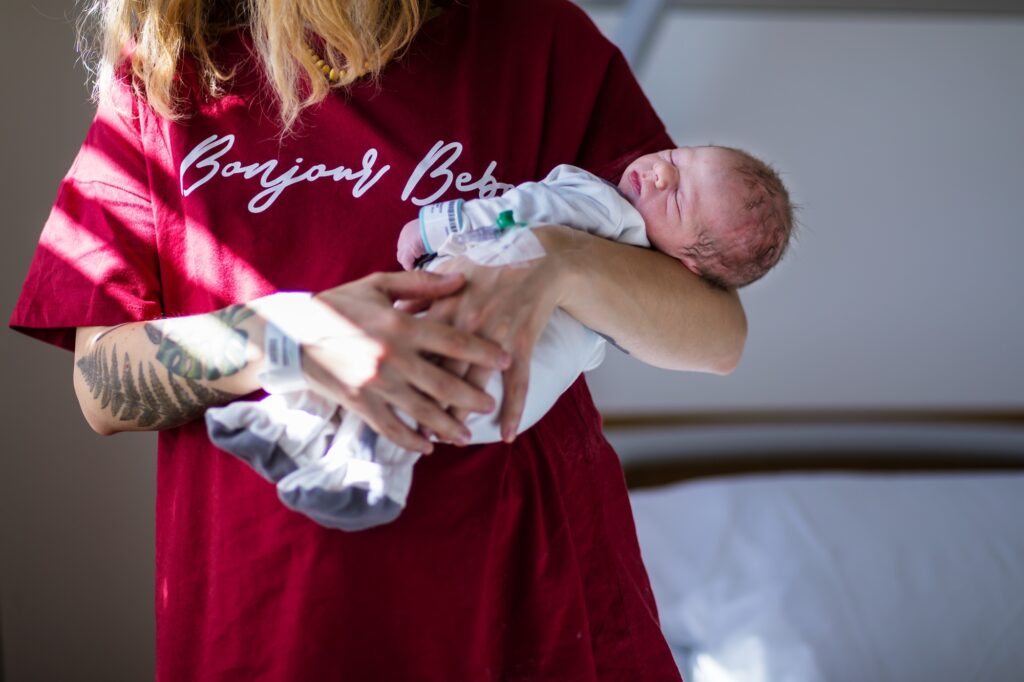 after giving birth a woman holds a baby in her arms