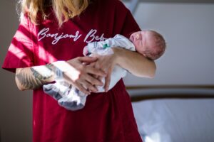 after giving birth a woman holds a baby in her arms